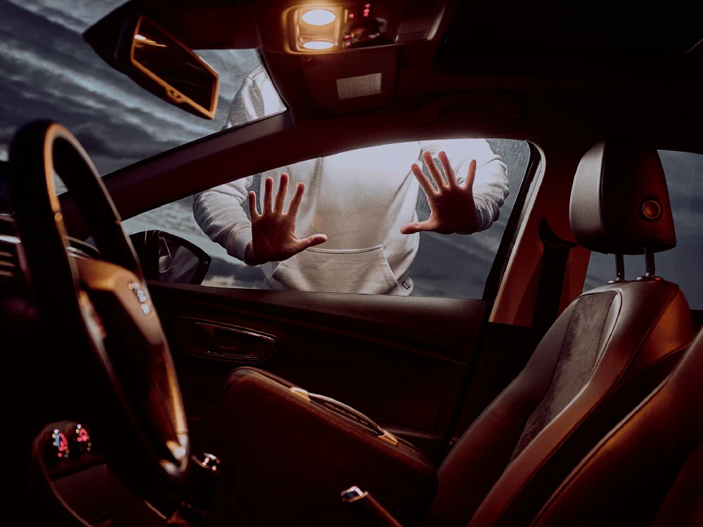 A driver behind the wheel of a modern car, hands on the steering wheel — extending trust to a vehicle increasingly governed by someone else’s software